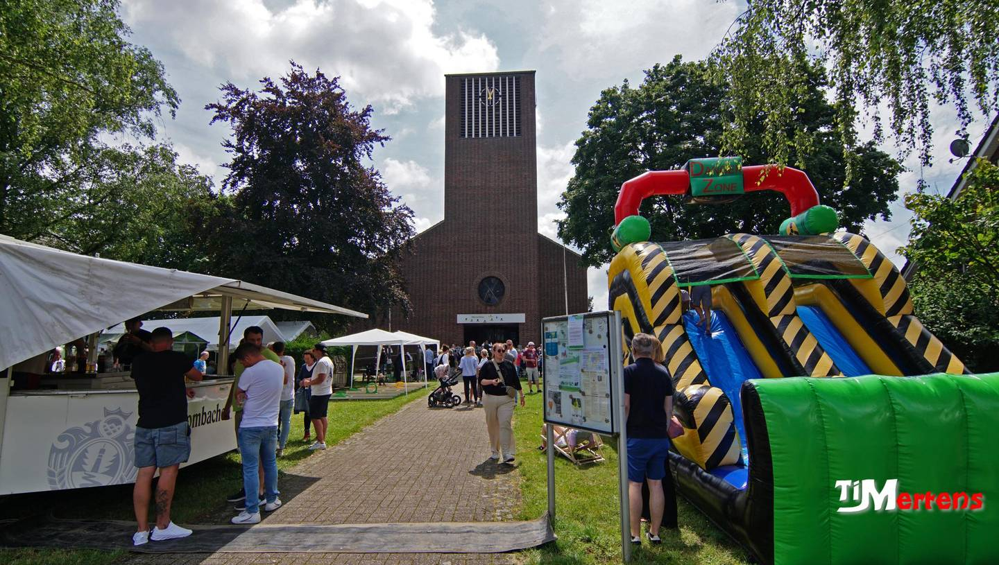 Ansicht auf die Kirche, mit vielen Ständen und Menchen am sonnigen Kirchweihfest