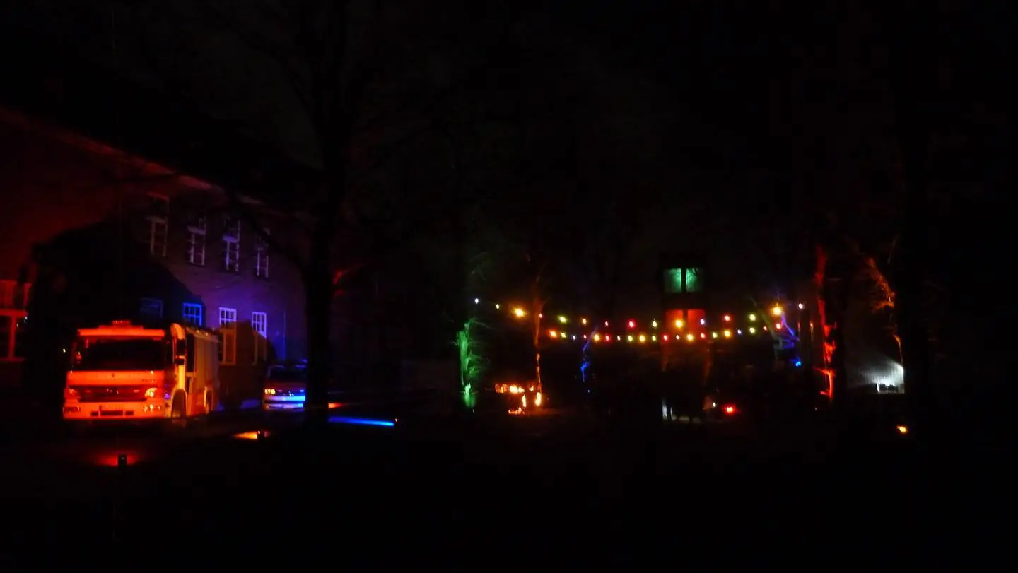 Ansicht der Feuerwehrfahrzeuge und dem Feuerwehrgerätehaus im Dunkeln beim Start des lebendigen Adventkalender in Gellep-Stratum